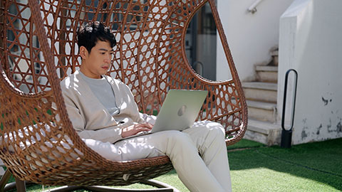 Happy mid adult Chinese man using laptop on hanging-chair,4K