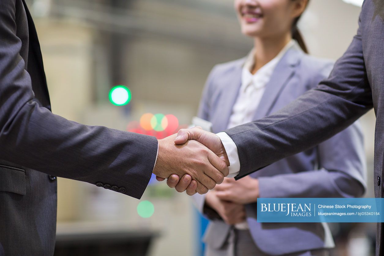 Business people shaking hands in the factory