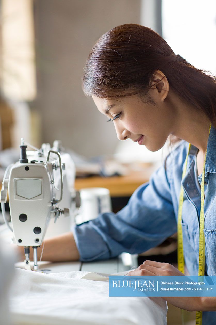 Chinese fashion designer using sewing machine