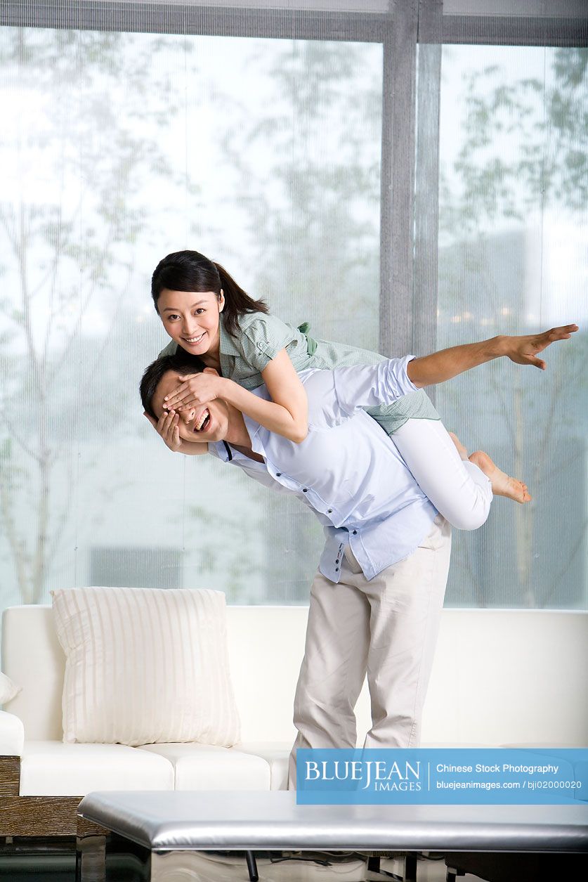 Portrait of  Chinese couple plying in living room