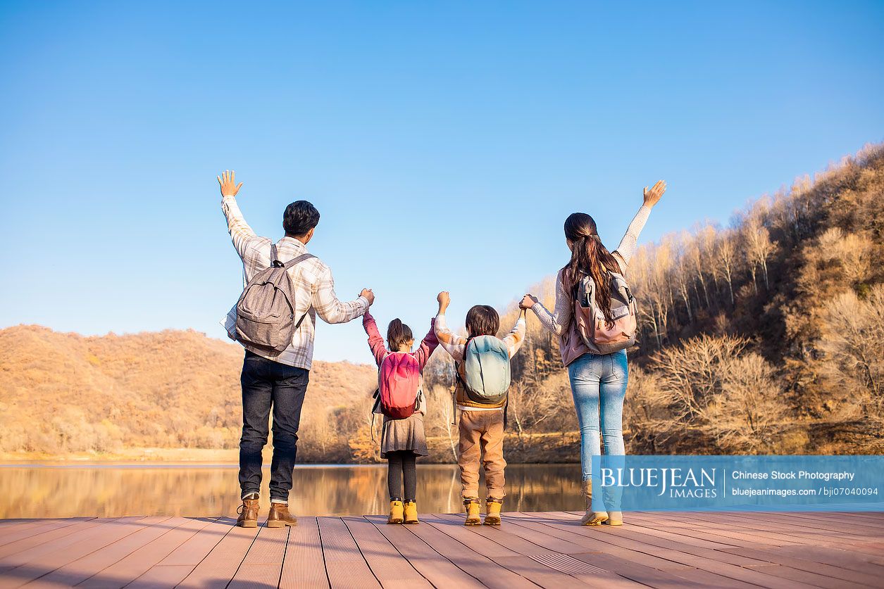 Cheerful young Chinese family enjoying the beautiful natural scenery