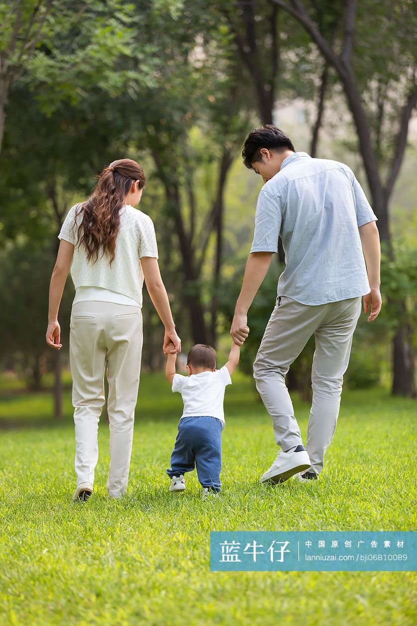 年轻父母在公园陪宝宝玩耍