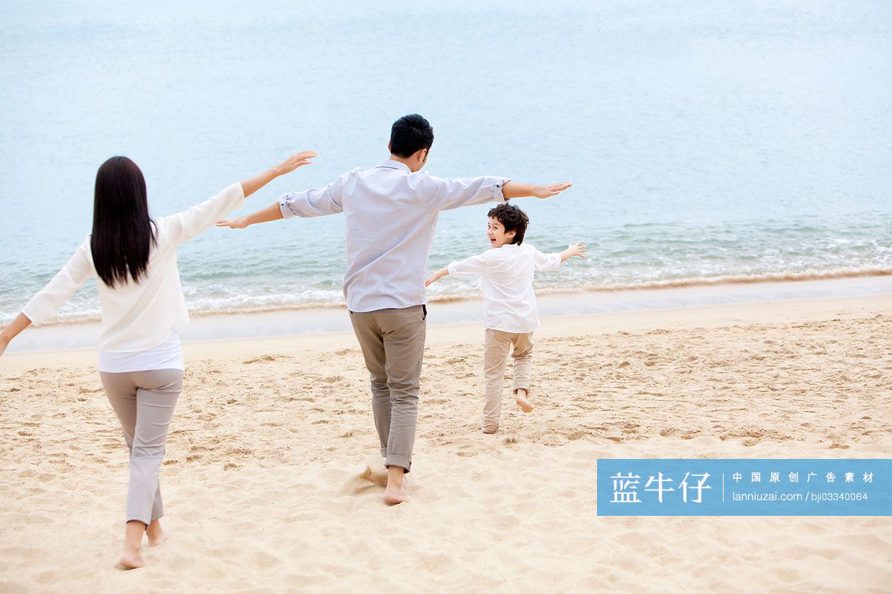 快乐的一家三口在沙滩上玩耍