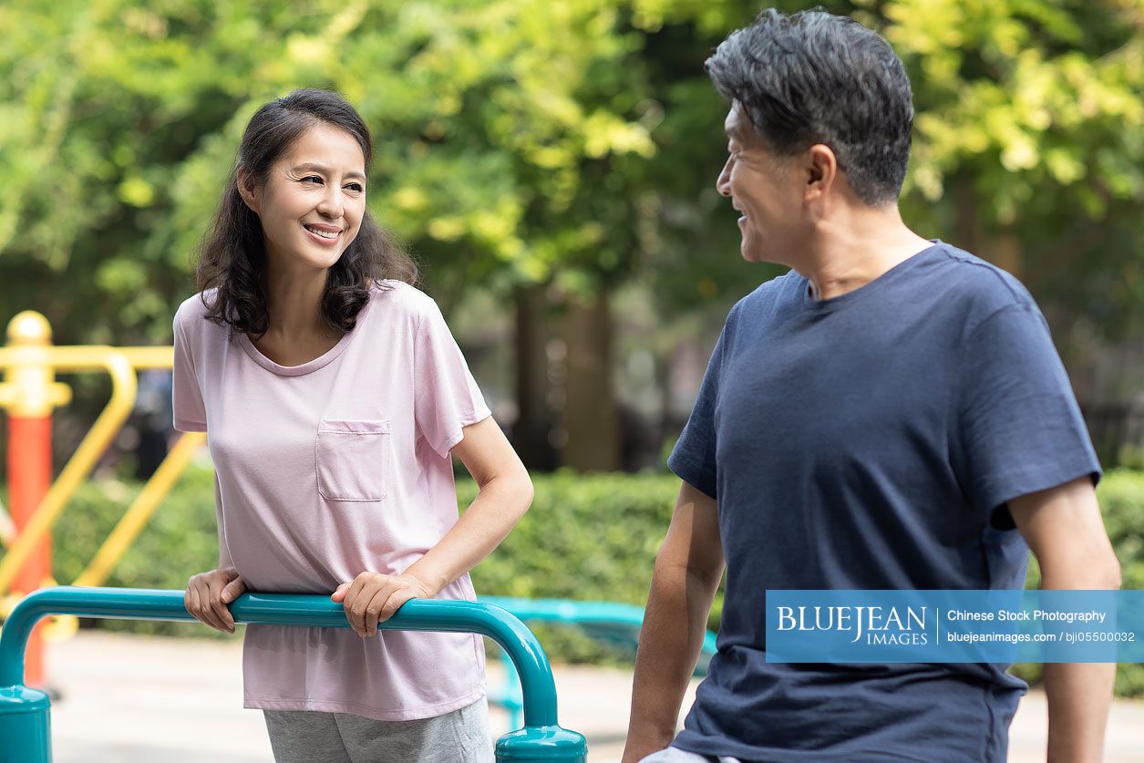 Happy mature Chinese couple exercising in park