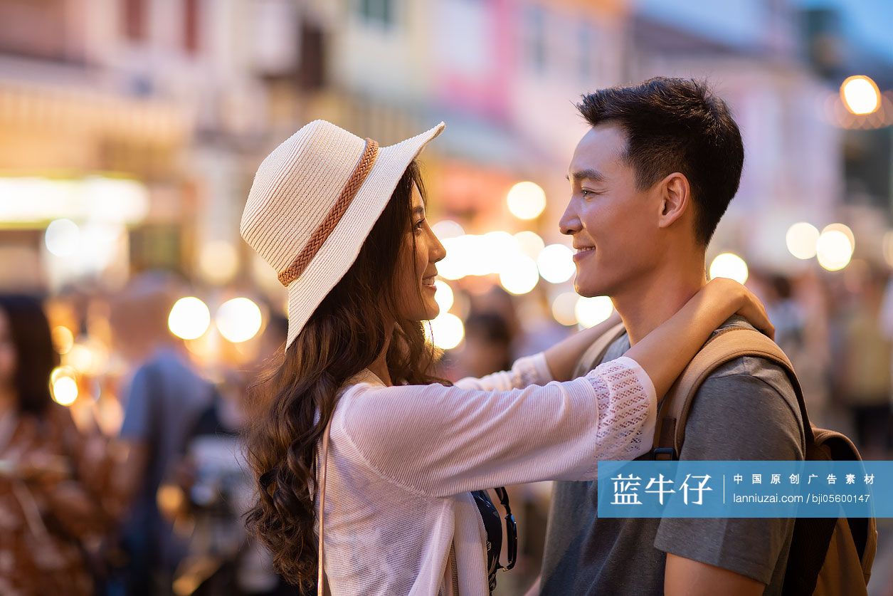 快乐的年轻情侣逛街头集市