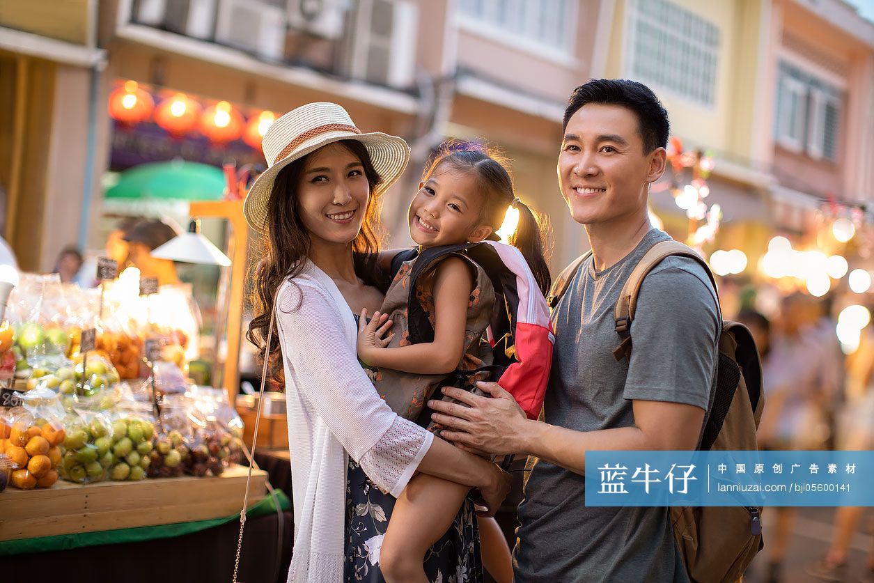 快乐的年轻家庭逛街头集市