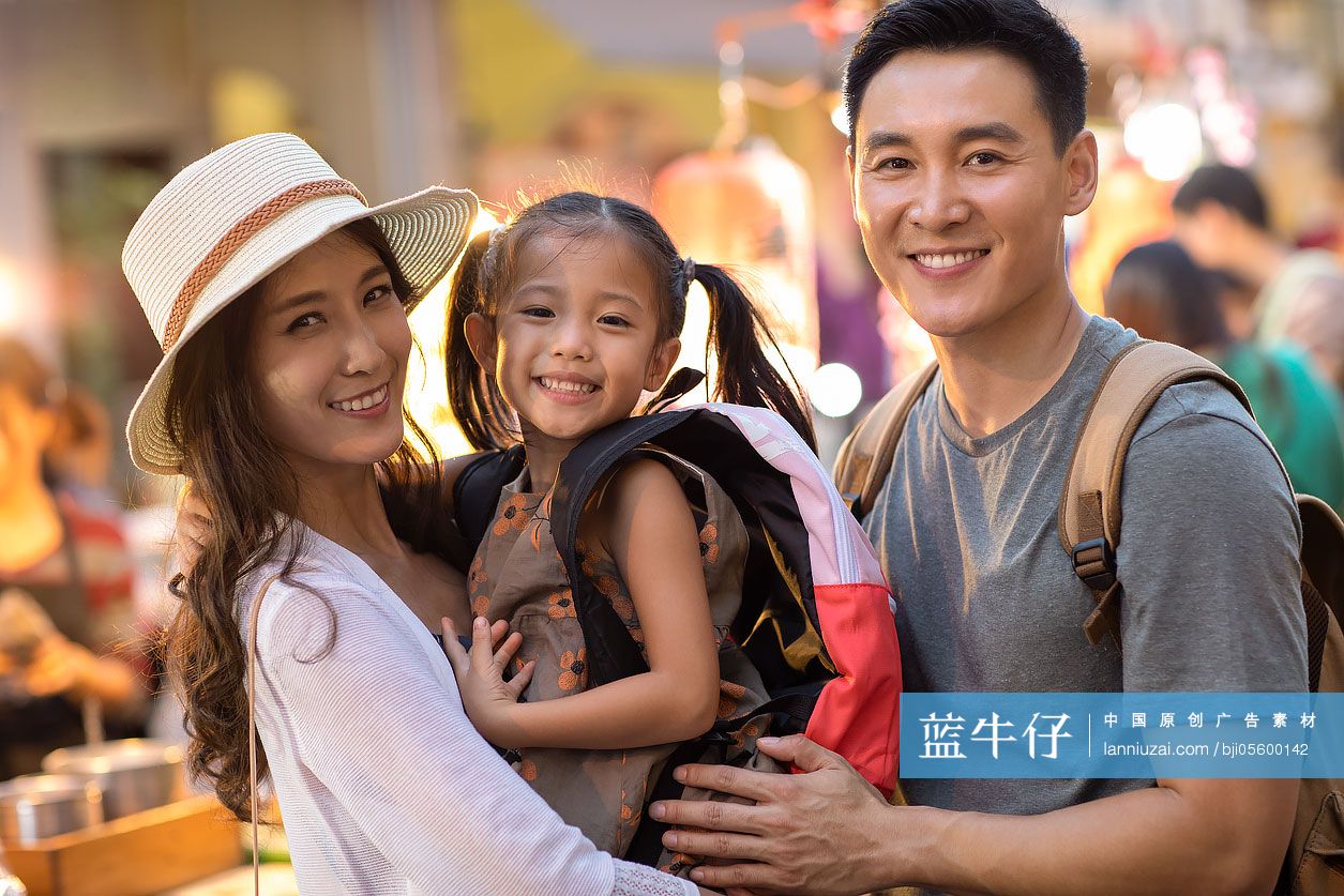 快乐的年轻家庭逛街头集市