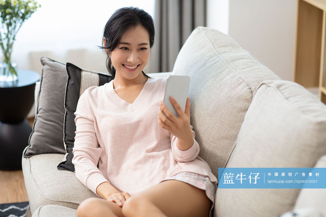 快乐年轻女士在家使用手机视频通话