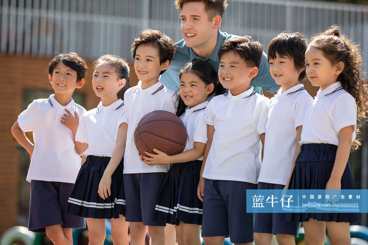 外教和孩子在操场打篮球