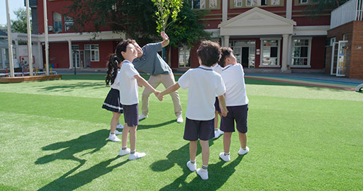 Foreign teacher and students playing in kindergarten playground,4K