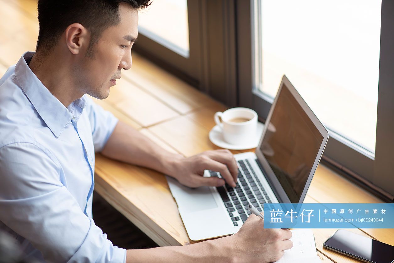 商务男子在咖啡馆使用笔记本电脑工作