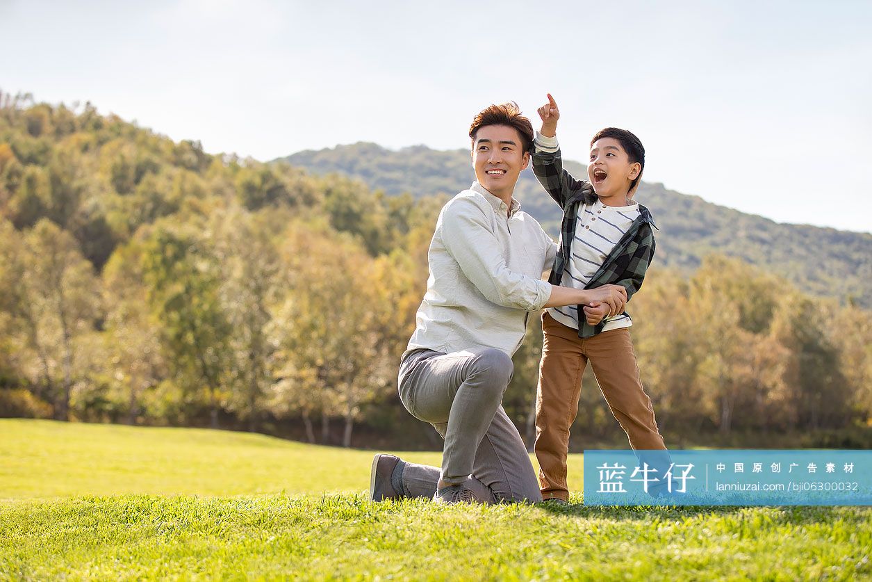 快乐的的父子俩在草地上玩耍