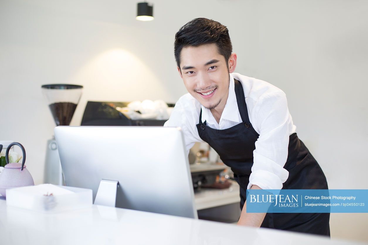 Chinese coffee shop owner using computer