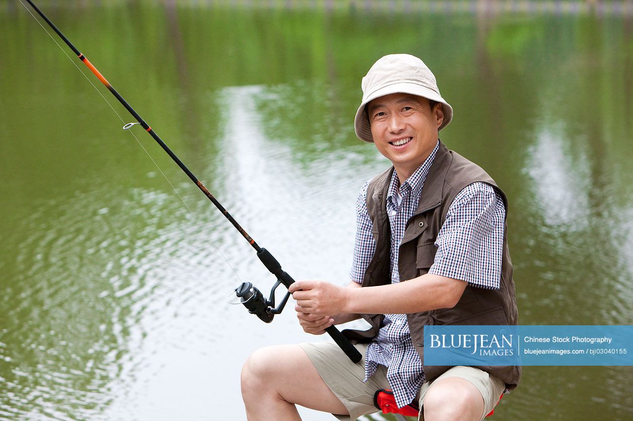 Old Chinese man fishing by a pond-High-res stock photo for download