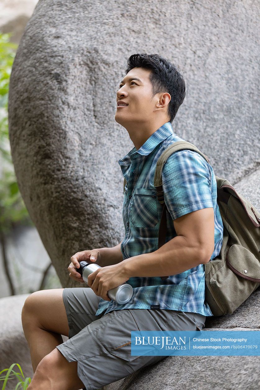 Young Chinese man hiking outdoors