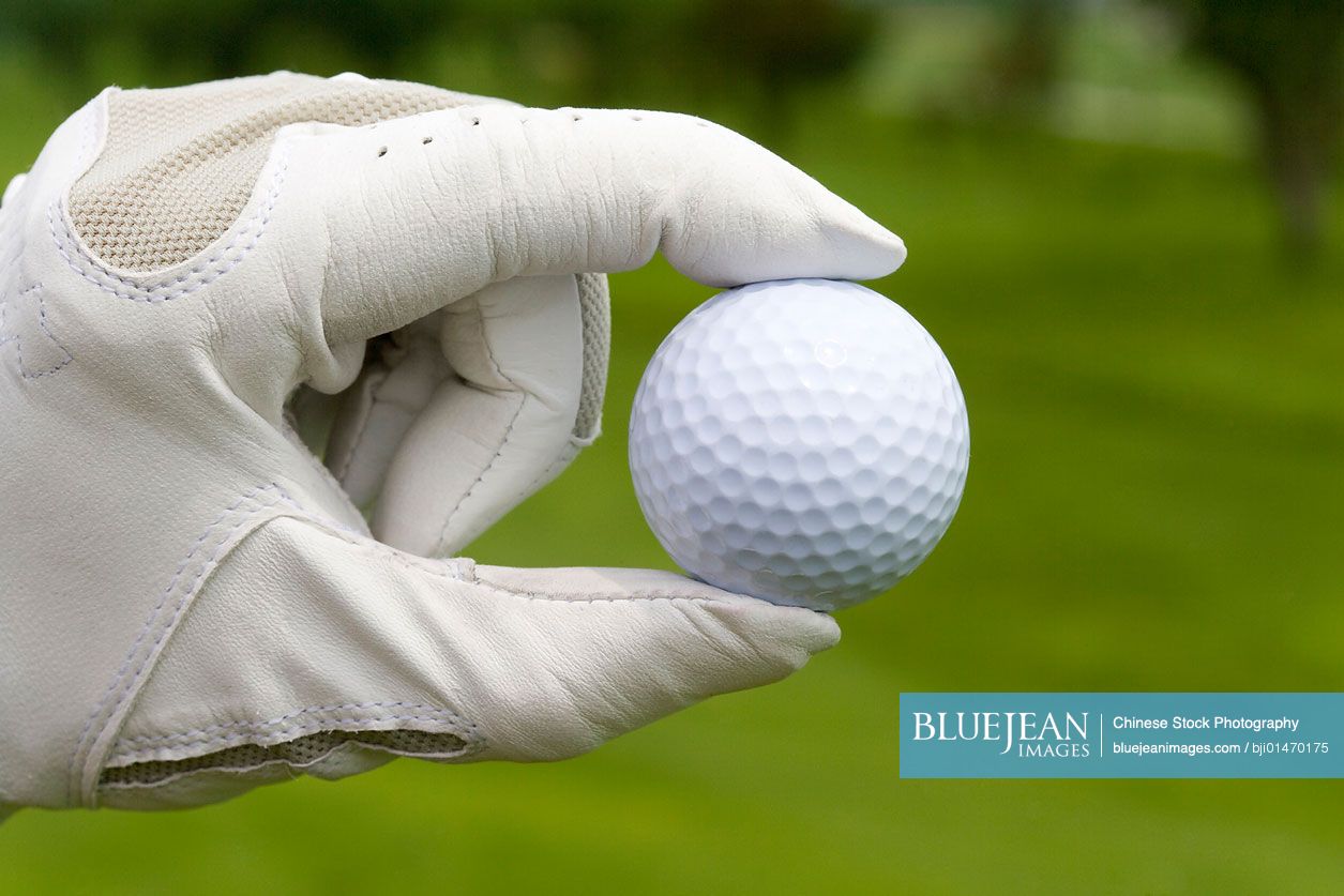 Close-up of a golf ball in golfer's hand