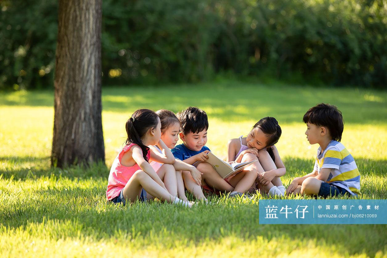 快乐的儿童在草地上读书