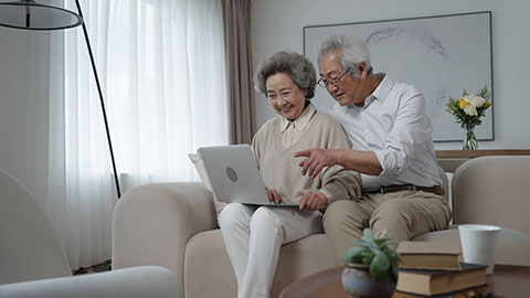 Cheerful senior Chinese couple using laptop at home,4K