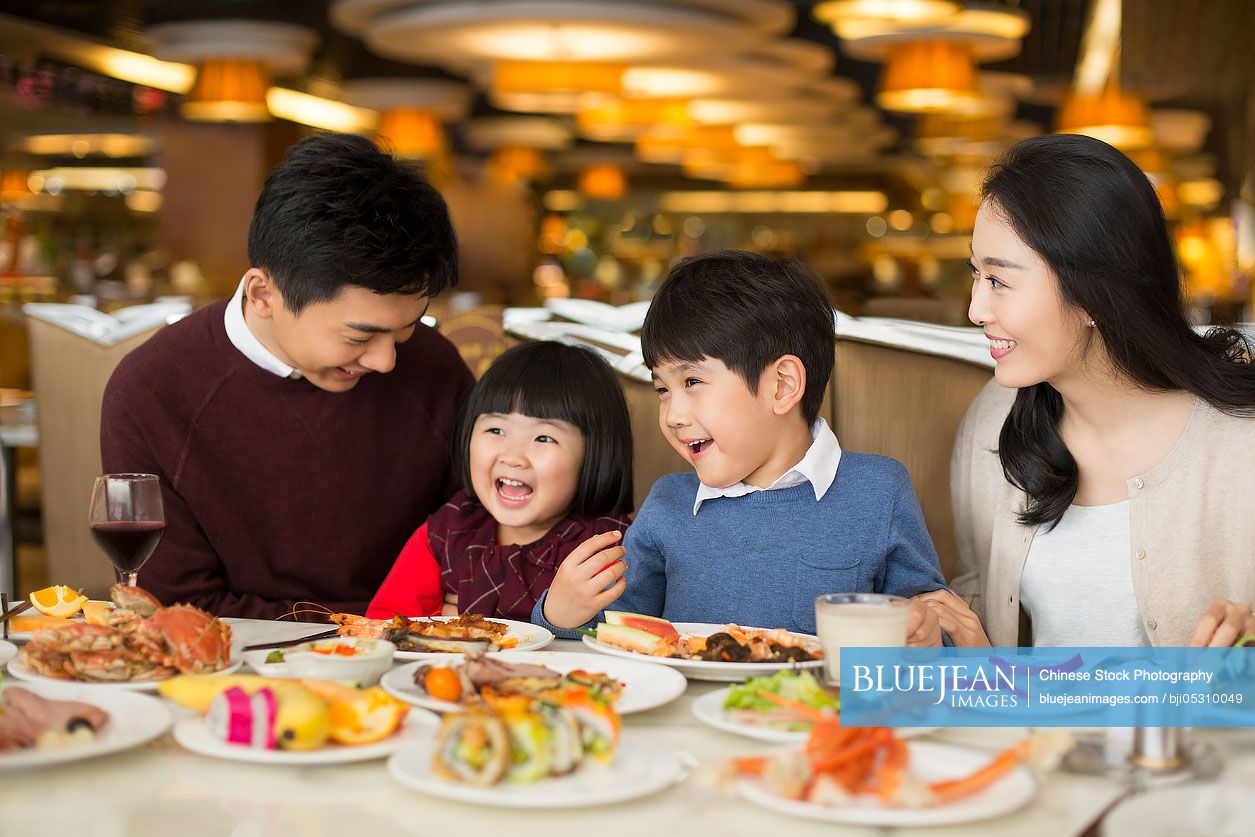 Cheerful young Chinese family having buffet dinner