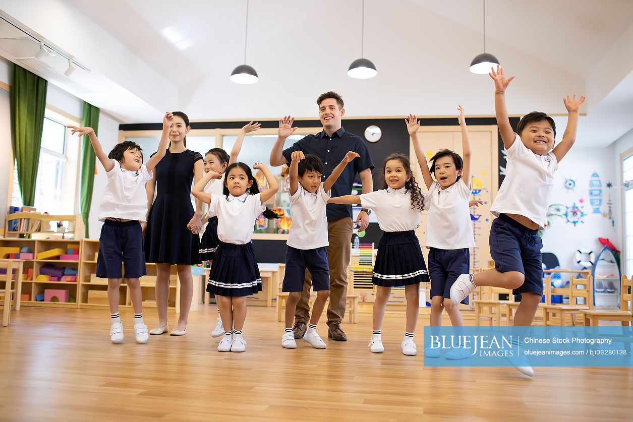 Teachers and children playing in classroom
