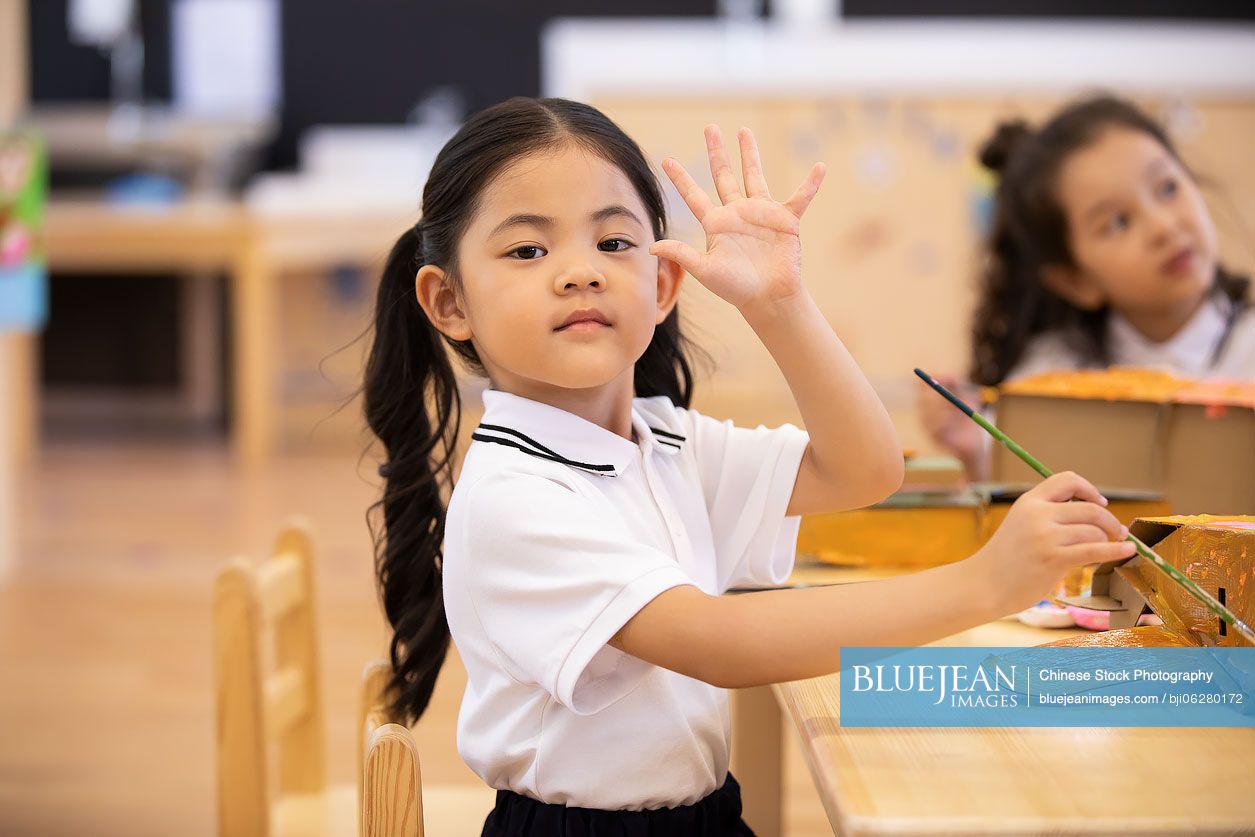 Little Chinese girl having art class in classroom