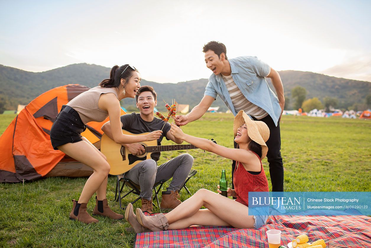 Happy young Chinese friends having a picnic outdoors