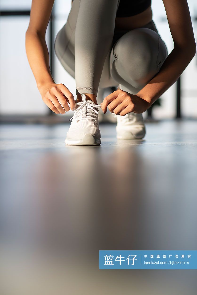 年轻女士在健身房系鞋带