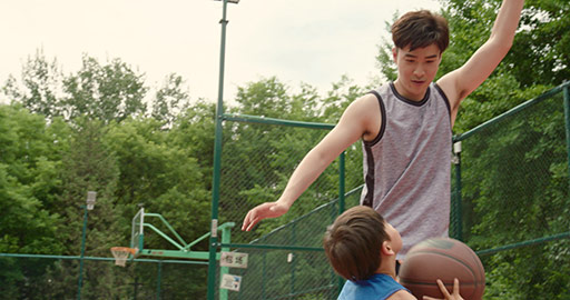 Chinese father and son playing basketball in park,4K