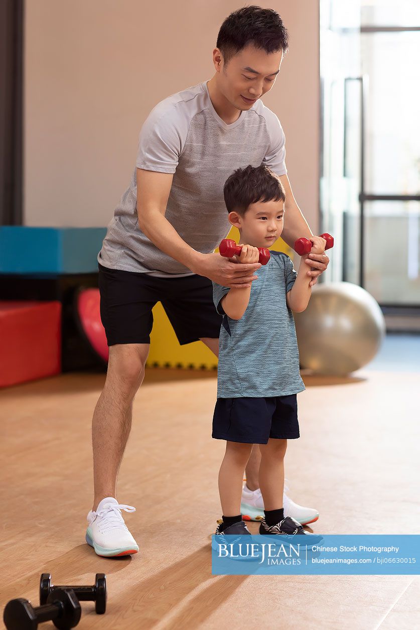 Little Chinese boy having exercise class in gym