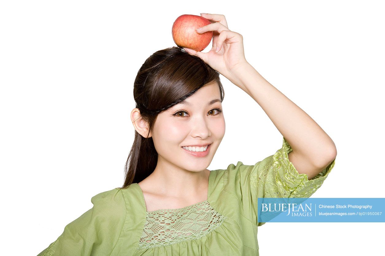 Portrait of young Chinese woman with red apple