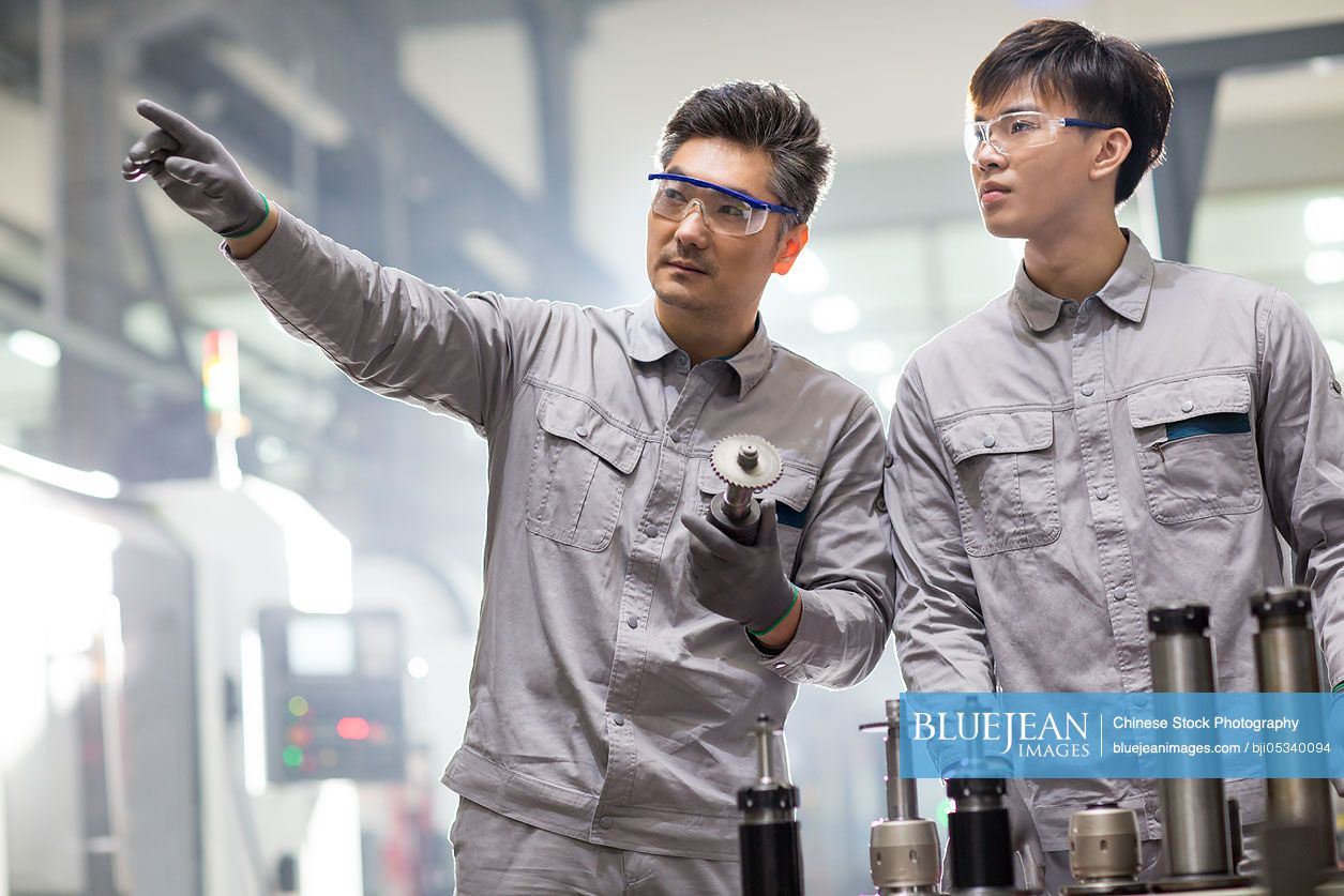 Confident Chinese engineers working in the factory