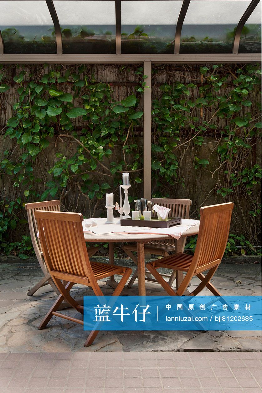 Veranda table and wooden chairs in house garden