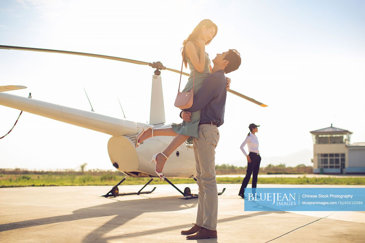 Young Chinese couple travelling by helicopter
