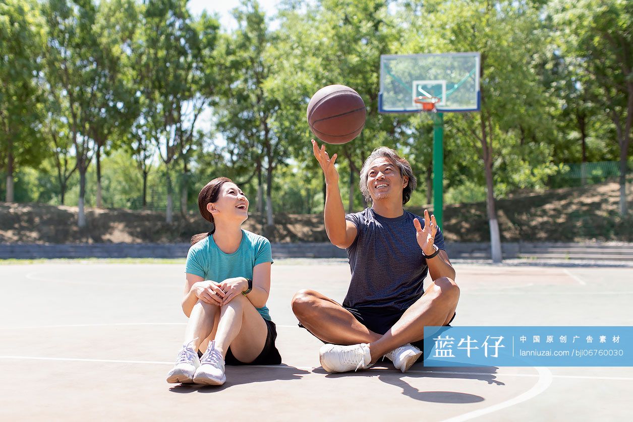 开心的中老年夫妇在篮球场休息