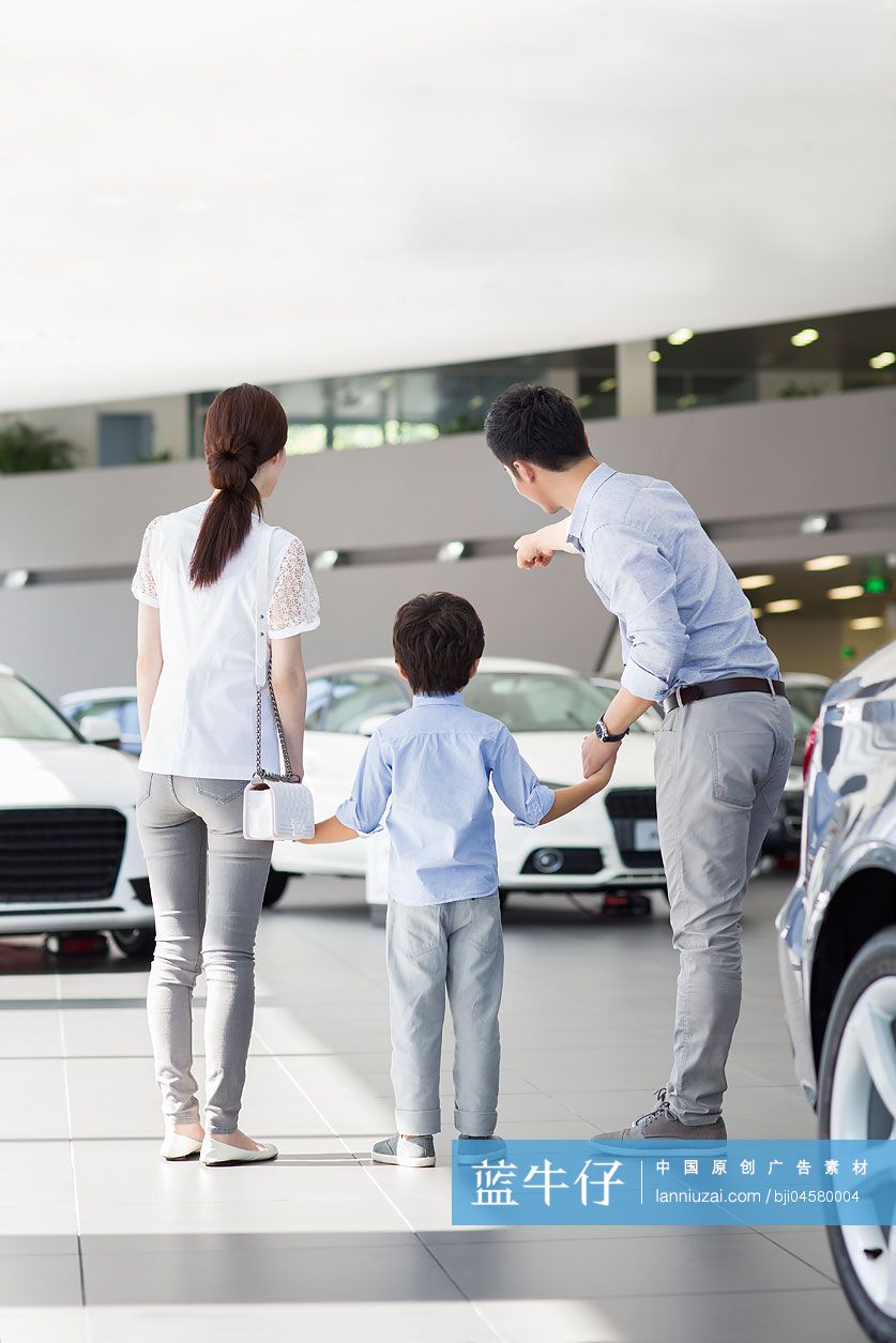 年轻家庭在4S店挑选汽车
