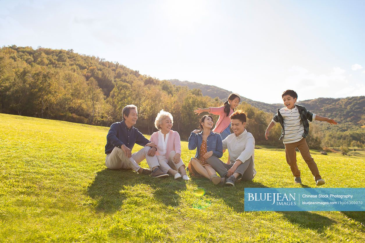 Happy Chinese family playing on meadow
