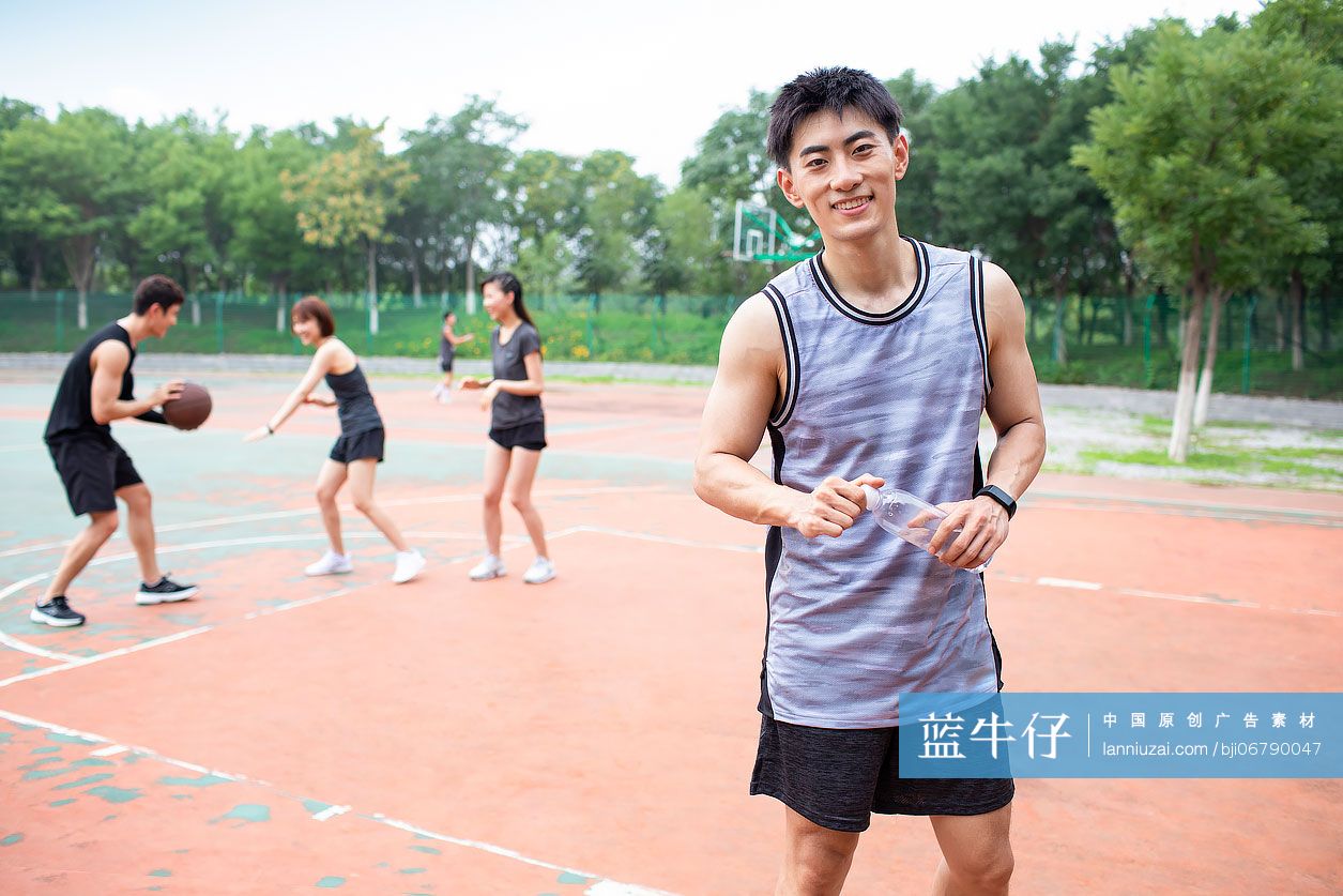 开心的年轻人在篮球场打篮球