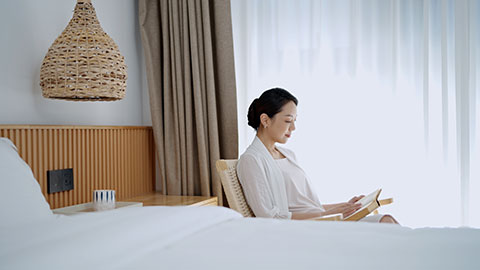 Elegant young Chinese woman reading book at home,4K