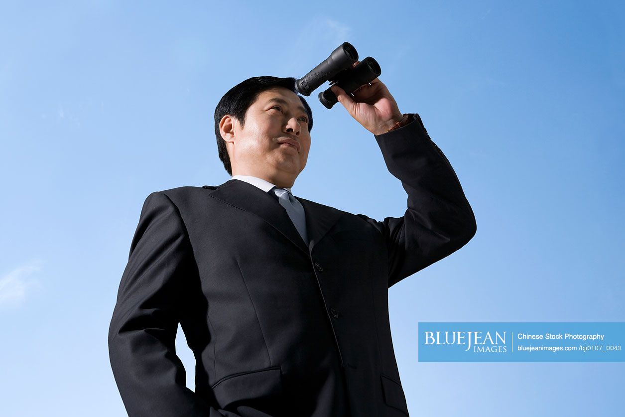 A businessman looks to the future with binoculars