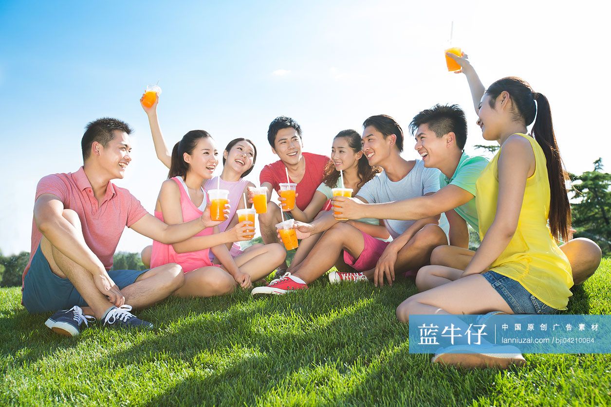 一群朋友坐在草地上喝饮料