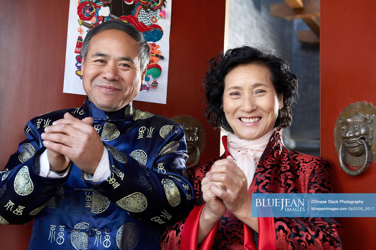 Happy senior Chinese man and woman wearing traditional clothing