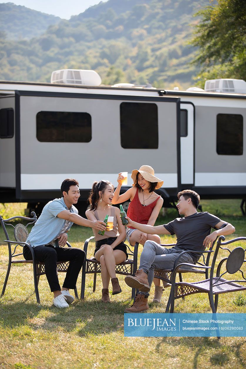 Happy young Chinese friends having a picnic outdoors
