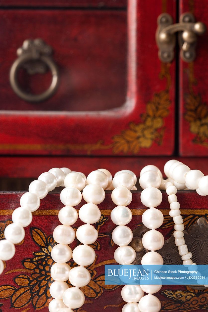 Close-up of Chinese cabinet with pearl necklace