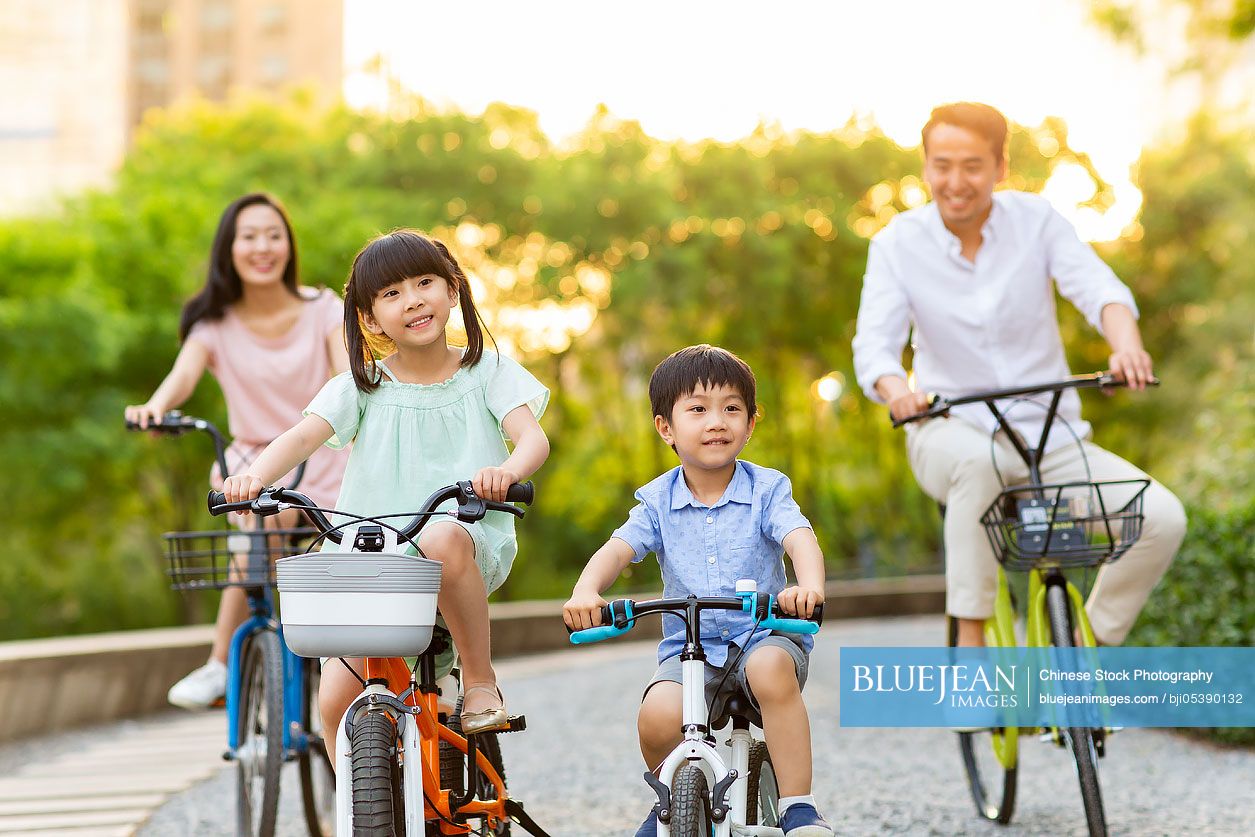 Happy young Chinese family riding bikes