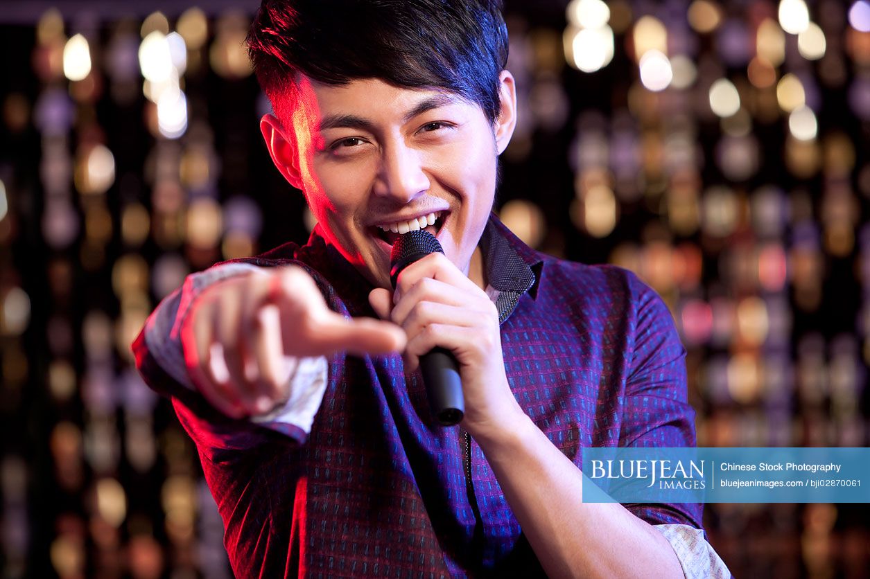 Young Chinese man singing Karaoke