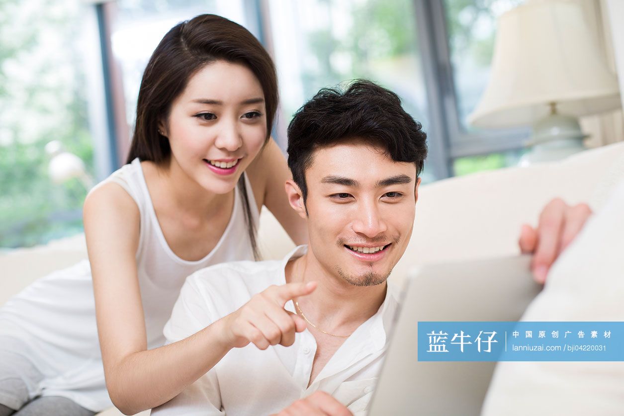 年轻情侣在客厅使用平板电脑-蓝牛仔影像-中国原创广告影像素材