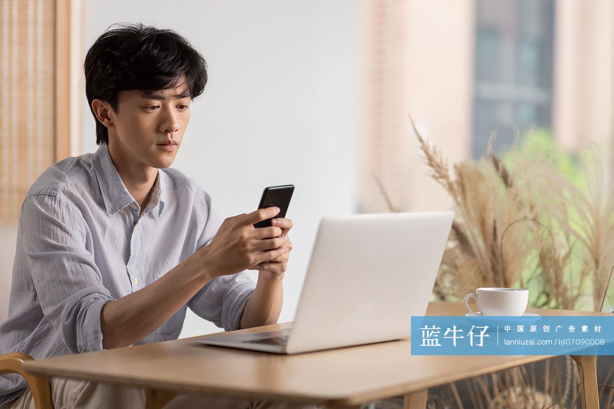 年轻男子在咖啡馆使用手机
