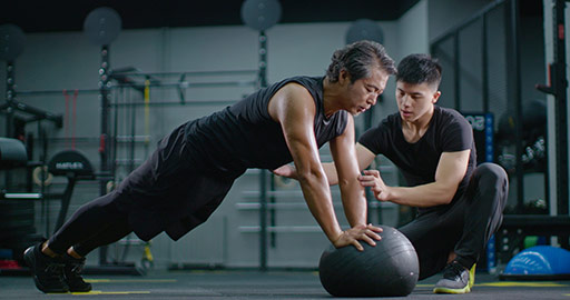 Mature Chinese man working out with personal trainer at gym,4K