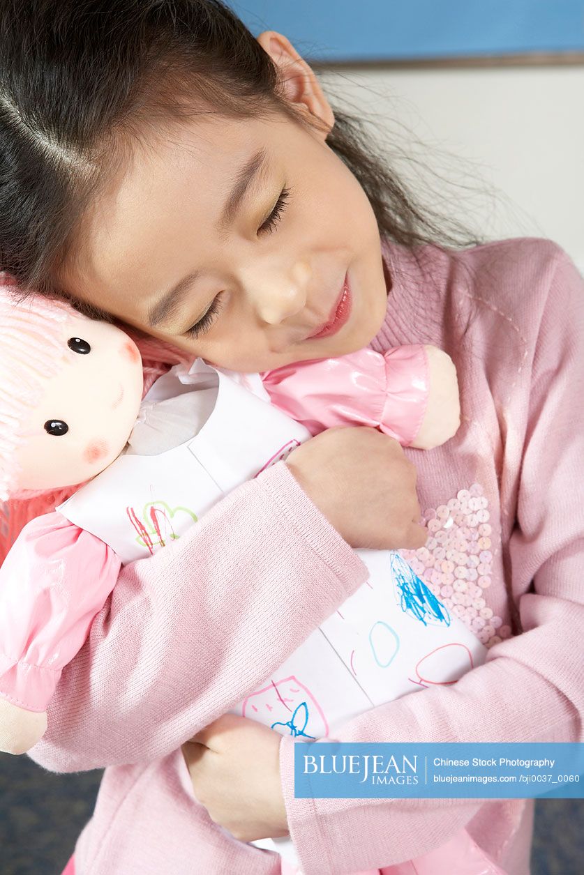 Chinese Girl Hugging Doll With Eyes Closed