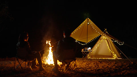 Happy young Chinese couple camping outdoors